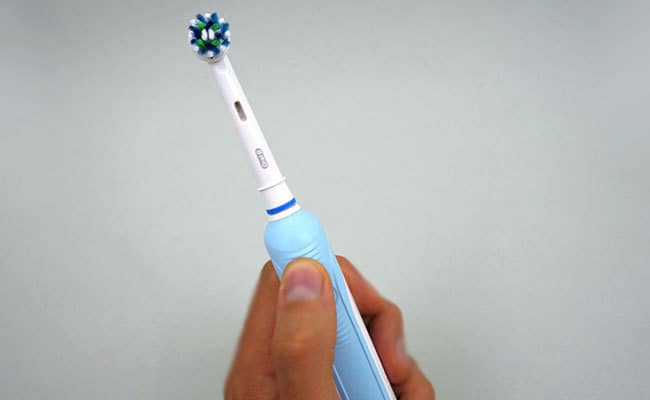 Oral-B Pro 1000 Electric Toothbrush held in hand being tested